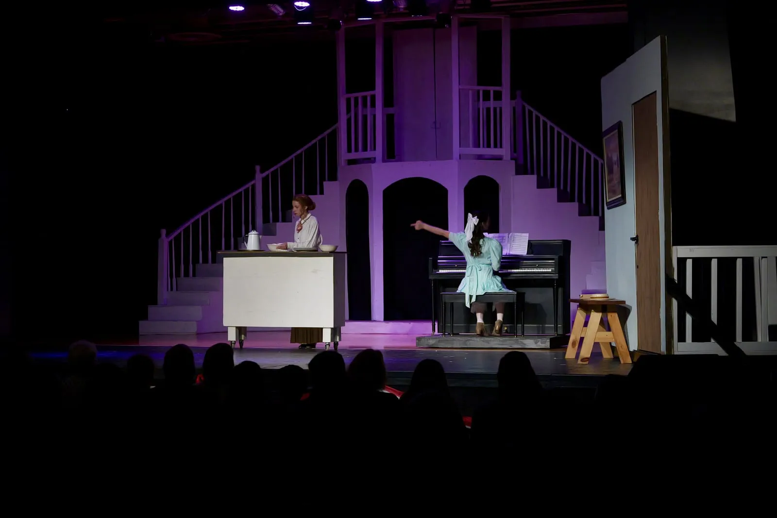 Two upper school students performing on stage in the school production, playing to a full house